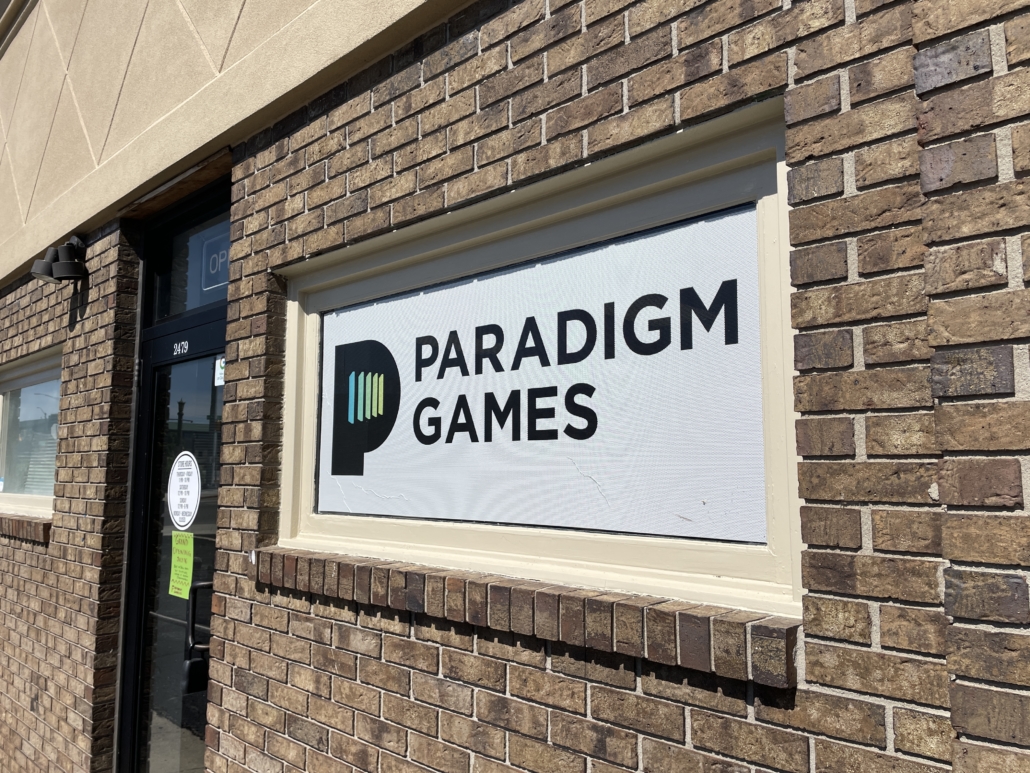 Storefrount of Paradigm Games with their signage hung that features their logo.
