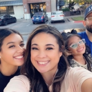 Family selfie with Francisco in the background and his wife holding the camera with his teenage daughter and young daughter behind her.