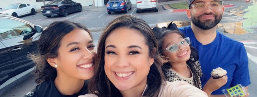 Family selfie with Francisco in the background and his wife holding the camera with his teenage daughter and young daughter behind her.