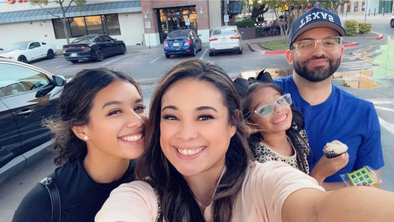 Family selfie with Francisco in the background and his wife holding the camera with his teenage daughter and young daughter behind her.